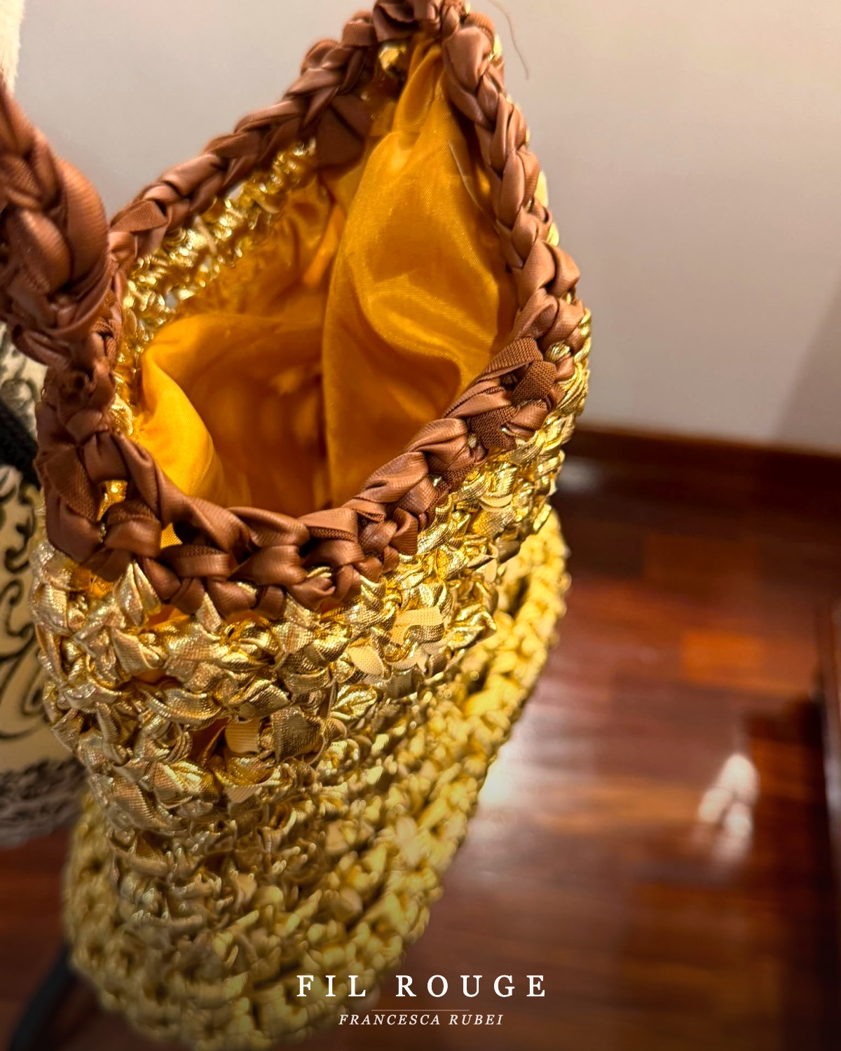 Close-up detail of the gold woven bucket bag